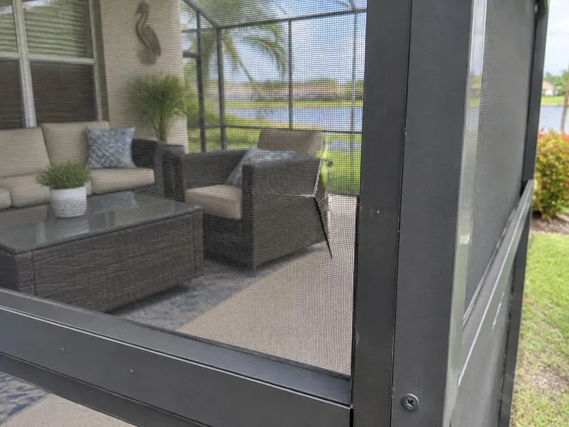 Torn screen panel on a lanai enclosure waiting for repair