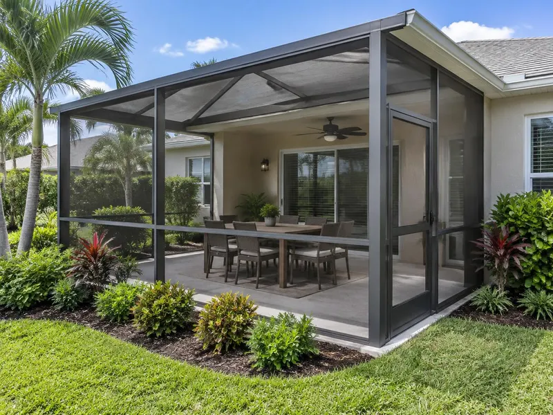 Patio screen enclosure with a dining area and screen door